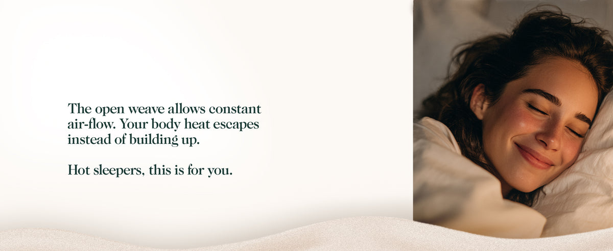 Woman smiling in bed under white sheets