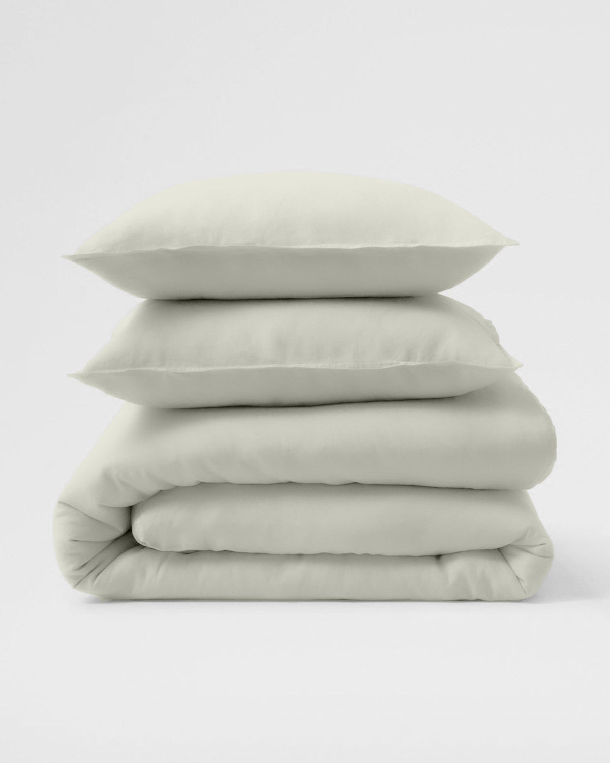 A folded stack of ivory Egyptian cotton percale sheets and pillowcases